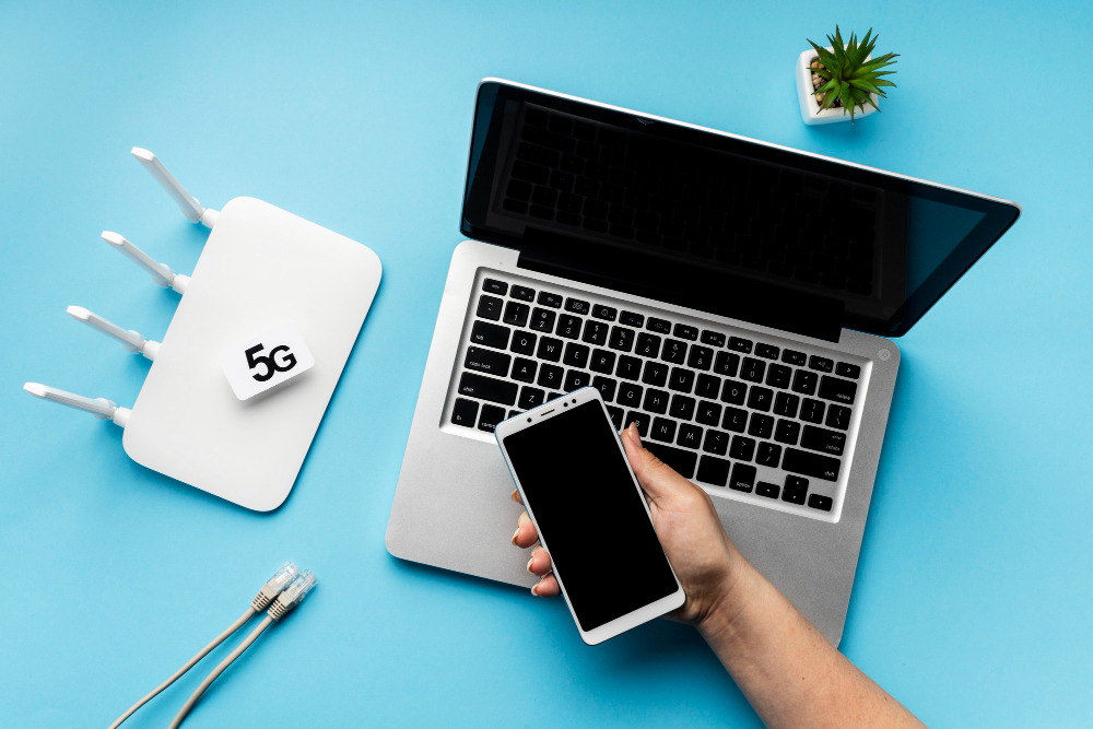 Top view of wi-fi router with laptop and hand holding smartphone