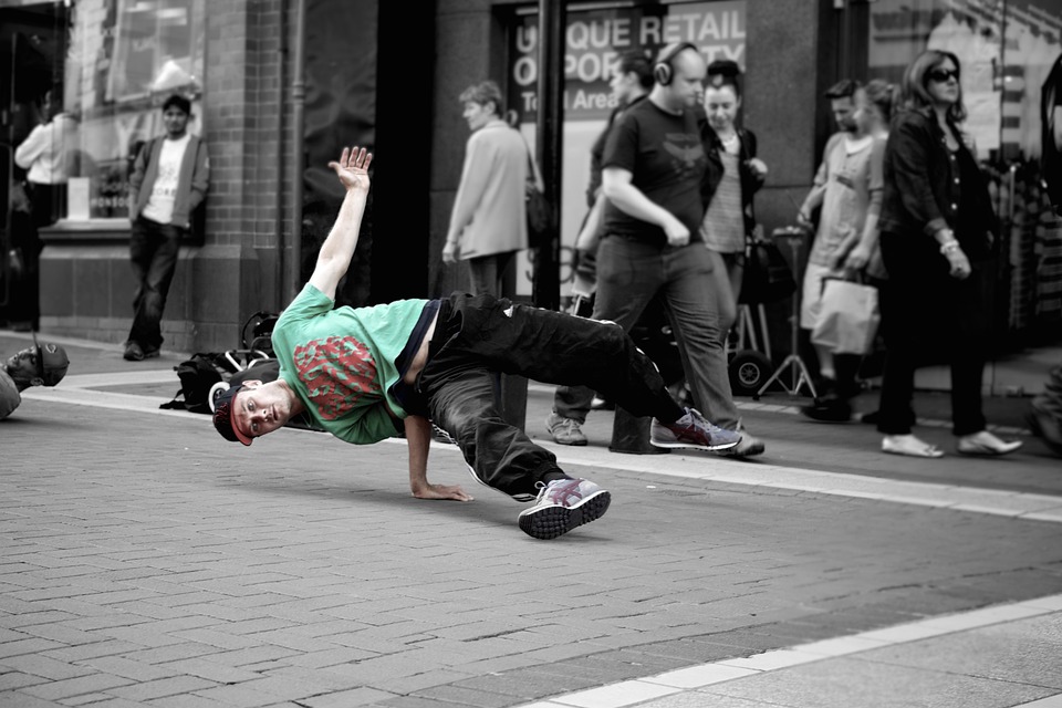 B-boy dancing in a public street with powerful moves of breakdancing