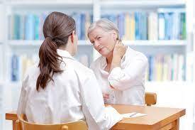 A woman consults with a doctor in a white coat, discussing her health in a professional medical setting.